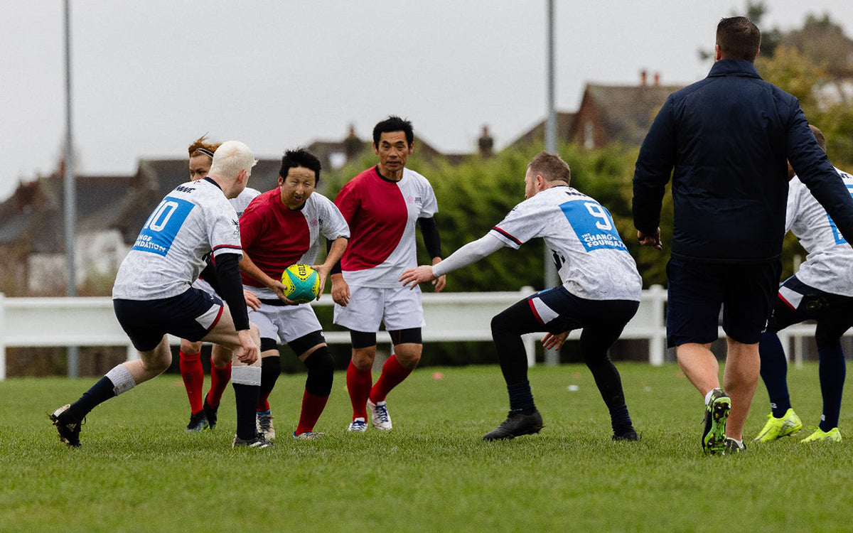 Game of VI rugby in progress. Two players about to tackle the ball carrier.