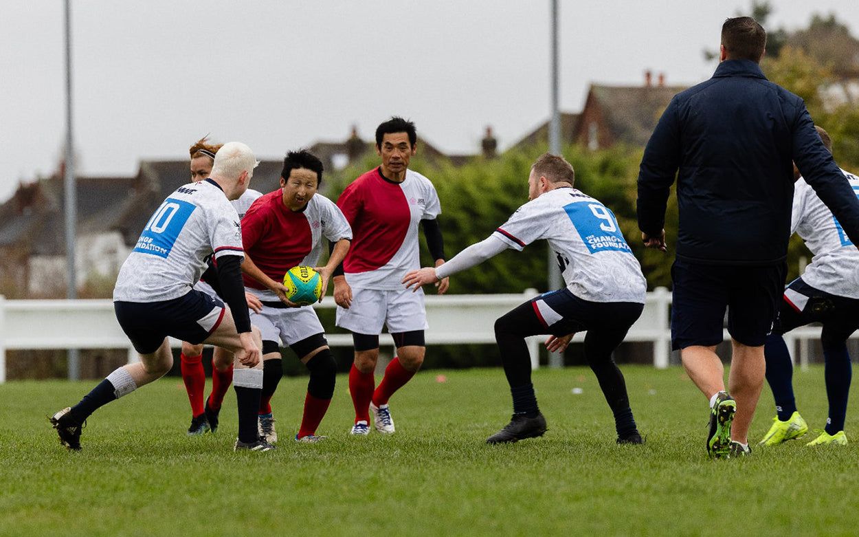 Game of VI rugby in progress. Two players about to tackle the ball carrier.