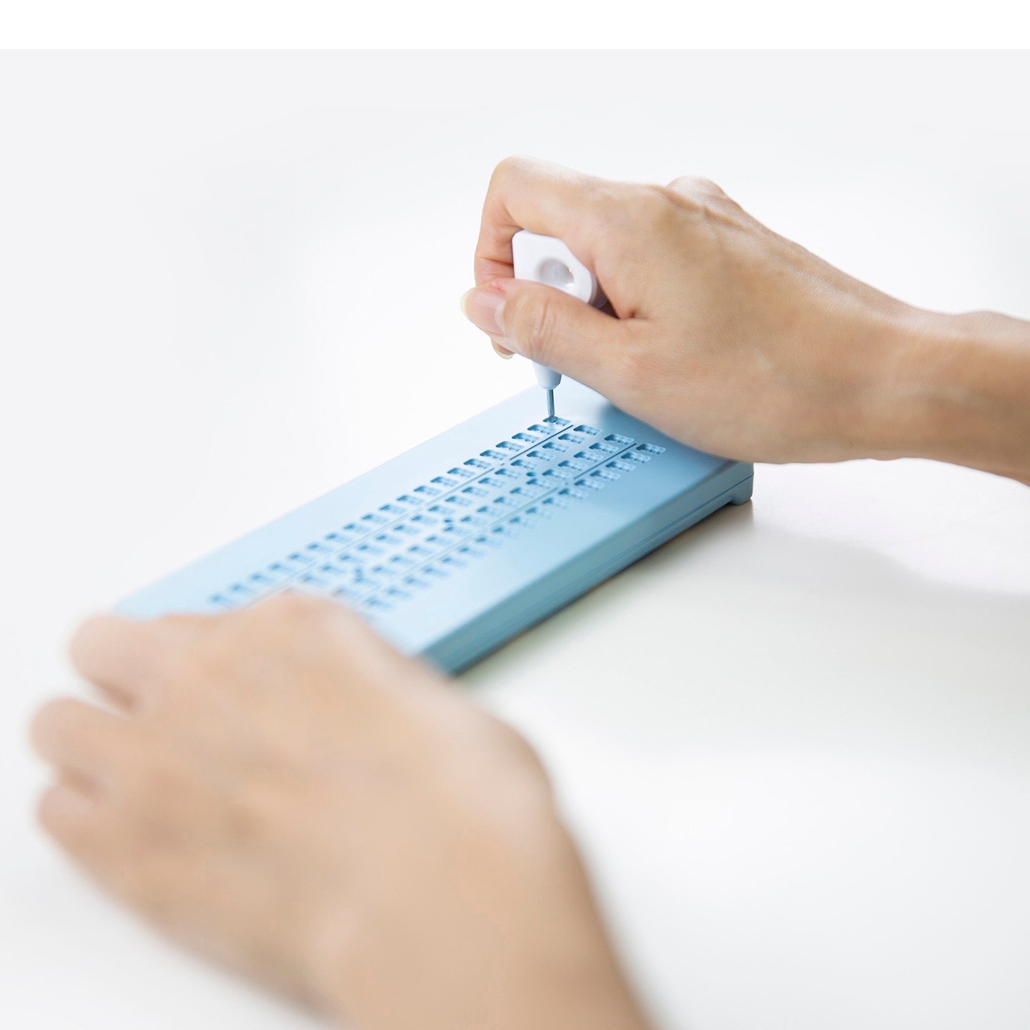 Someone using the paperless braille slate
