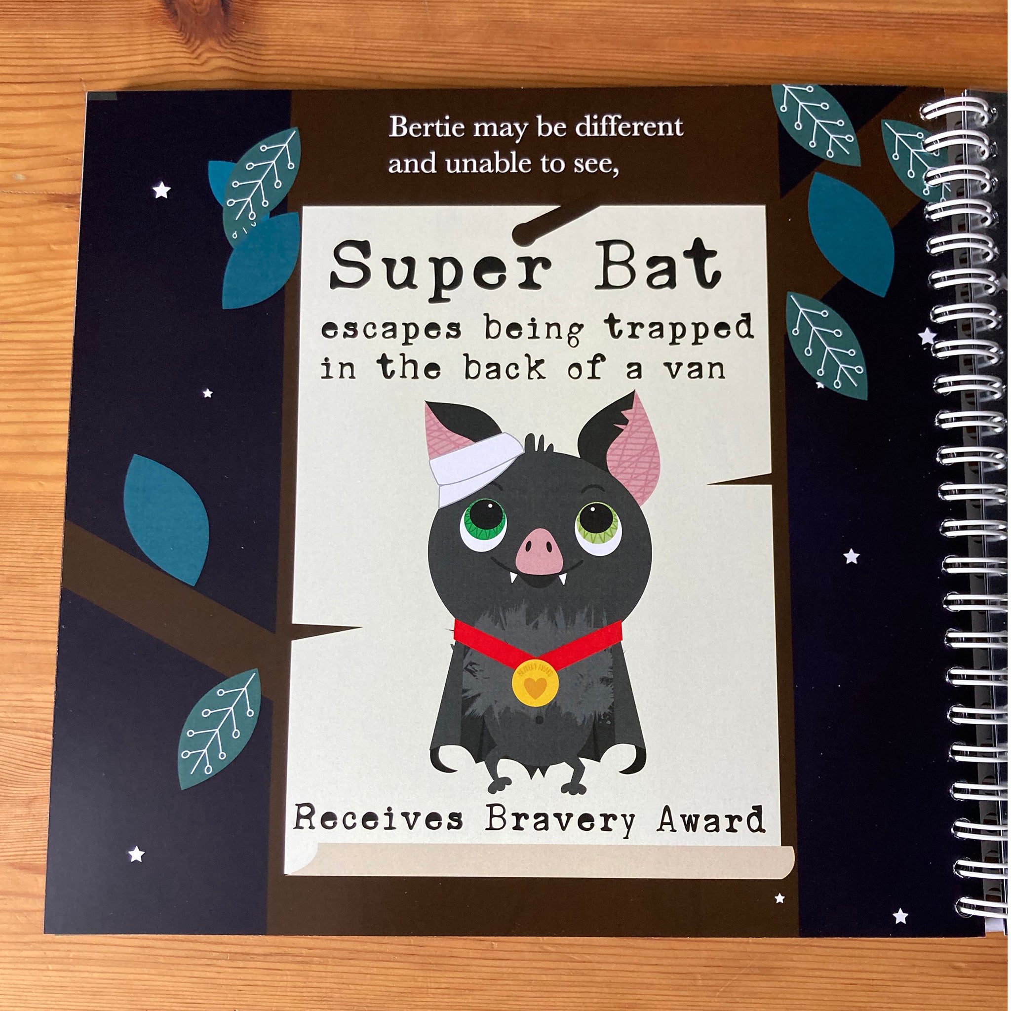 Bertie the very blind batopen to show a print page without the braille overlay and the wiro binding.