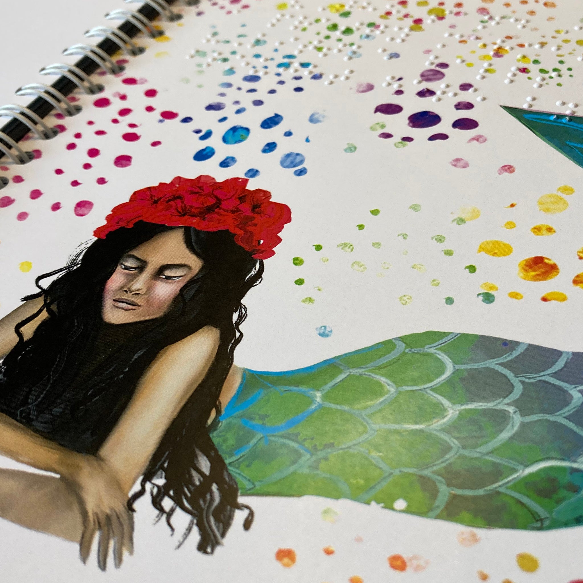 A page from Little turtle turns the tide shared reading book. The page has braille embossed above a drawing of a mermaid with long black hair.