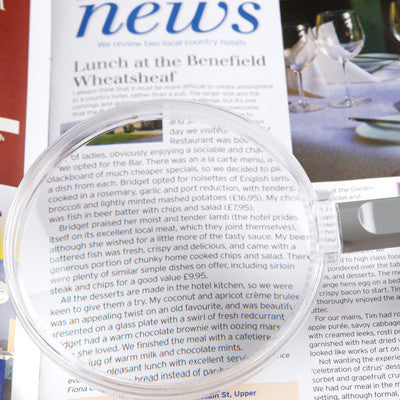 Close-up of magnifier on a magazine