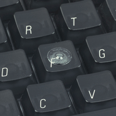 A clear loc dot attached to the F key on a computer keyboard