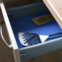 Non-slip material being used in a kitchen drawer with utensils placed on top