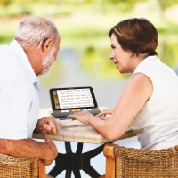 A man and a woman using the HD touchscreen magnifier