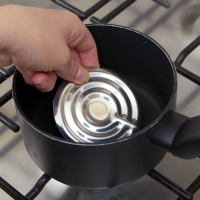 Close-up of a person putting the Boil alert into a pan