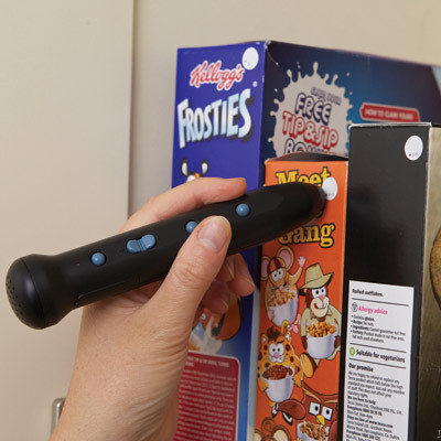 A person using an RNIB PenFriend to read a label on a cereal box
