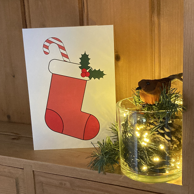 Inclusive Christmas stocking Christmas card on a shelf with Christmas decorations