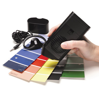 A person using the Talking Colour Detector to detect colours of paint sample cards