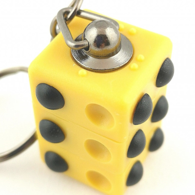 Braille cube keyring showing two sides, one with the letter L and one with a full six-dot cell