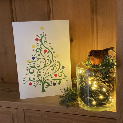 Inclusive Christmas tree Christmas card on a shelf with Christmas decorations