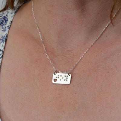 Bar-shaped silver pendant being worn
