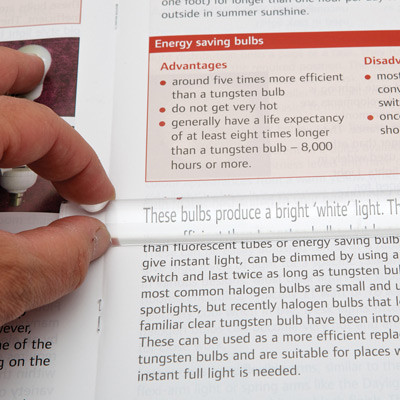 Close-up of a person using the magnifier to read a magazine