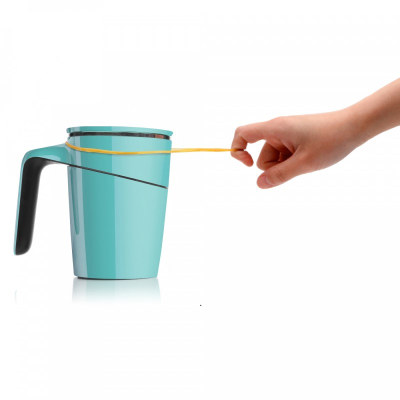 A person trying to tip over a blue anti-spill suction mug using a rubber band