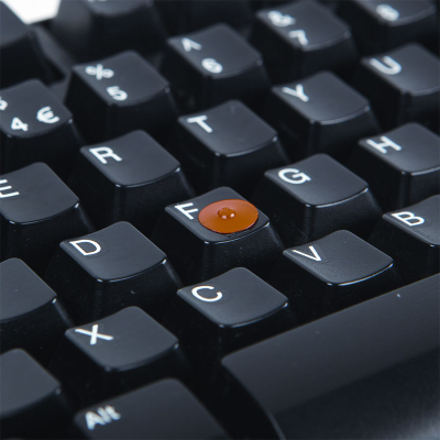 An orange loc dot attached to the F key on a computer keyboard
