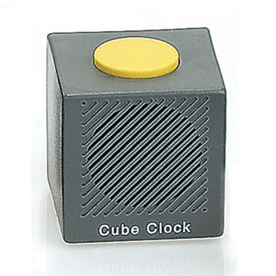 A simple grey cube shaped alarm clock with a large yellow button on top