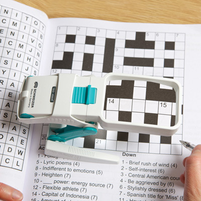 Close-up of a person using the magnifier to do a crossword