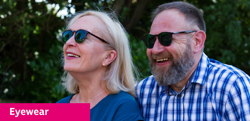 Couple sitting in the garden laughing and wearing tinted eyeshields