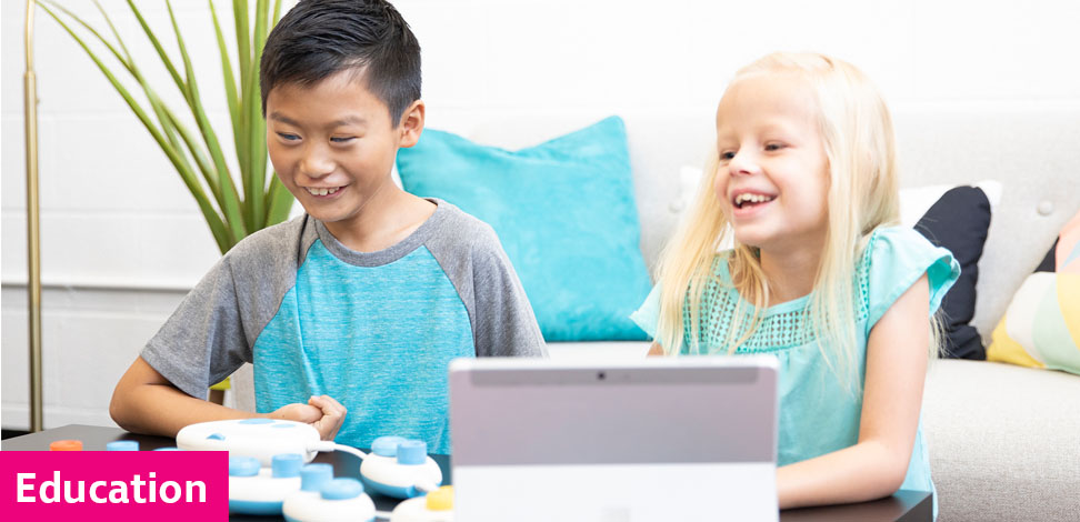 Two young children learning computing skills with Code Jumper