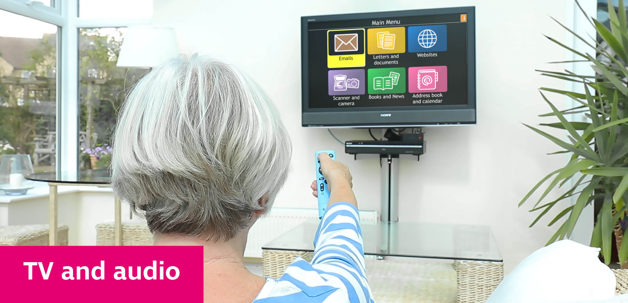 A white woman pointing a remote control to operate a TV