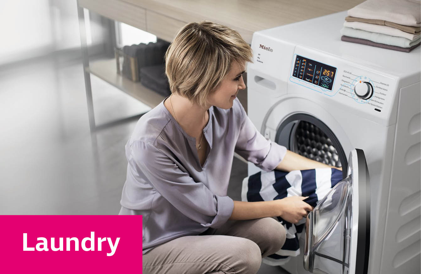 Lady placing clothes into the Miele Guideline washing machine