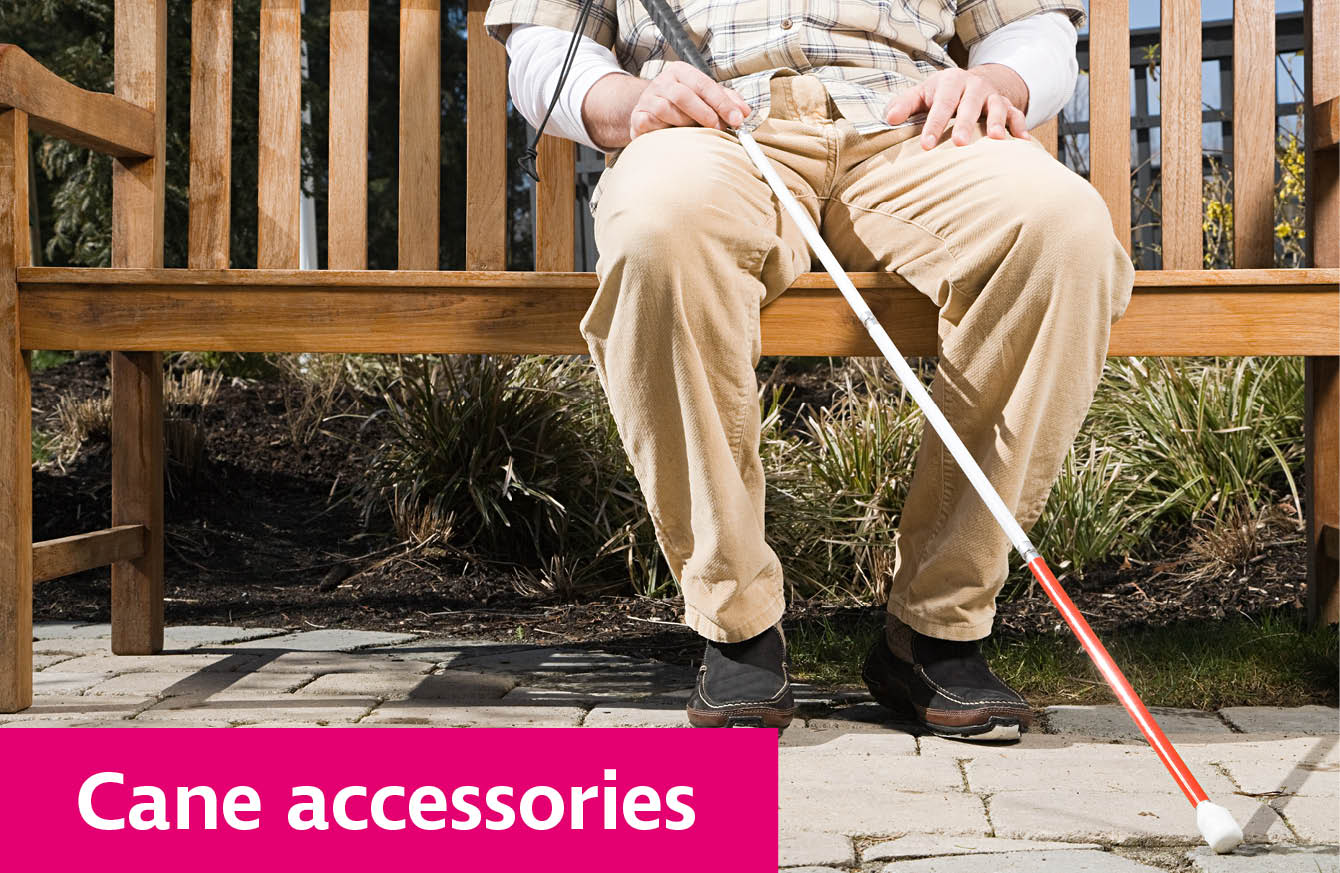 Someone sitting on a bench resting a cane on their leg