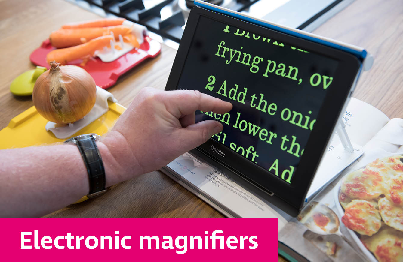 Someone using an electronic magnifier to read a recipe as they cook