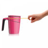 A person trying to tip a pink anti-spill suction mug using a rubber band