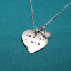 Front view of Heart-shaped silver necklace with ‘mum’ in braille and charm