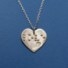 Front view of heart-shaped silver pendant against a white background
