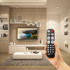 hand holding remote control in a living room setting