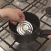 Water boil alert disc being placed in a saucepan