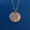 Front view of disc-shaped silver pendant