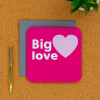 Big Love card on a desk with pen next to it