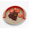 Red plate surround being used to hold fruit in place on a plate