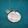 Back view of Disc-shaped silver necklace with ‘love’ in braille and charm