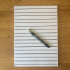 RNIB A4 White writing pad on a desk along with a pen