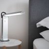 Image shows lamp in use in a modern style bedroom