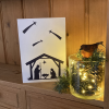 Inclusive Nativity Christmas card on a shelf with Christmas decorations