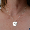 Heart-shaped silver pendant being worn