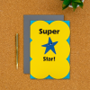 Super Star! Card on a desk with pen next to it
