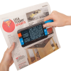 Hands holding theCompact+ HD portable video magnifier over a newspaper