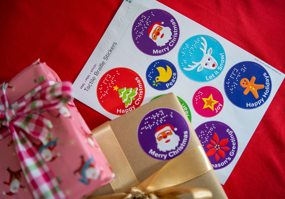 A sheet of colourful, tactile Christmas stickers with wrapped gifts on a red cloth