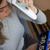 Woman using a digital thermometer to check her own temperature
