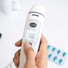 Digital thermometer being held with a blurred background