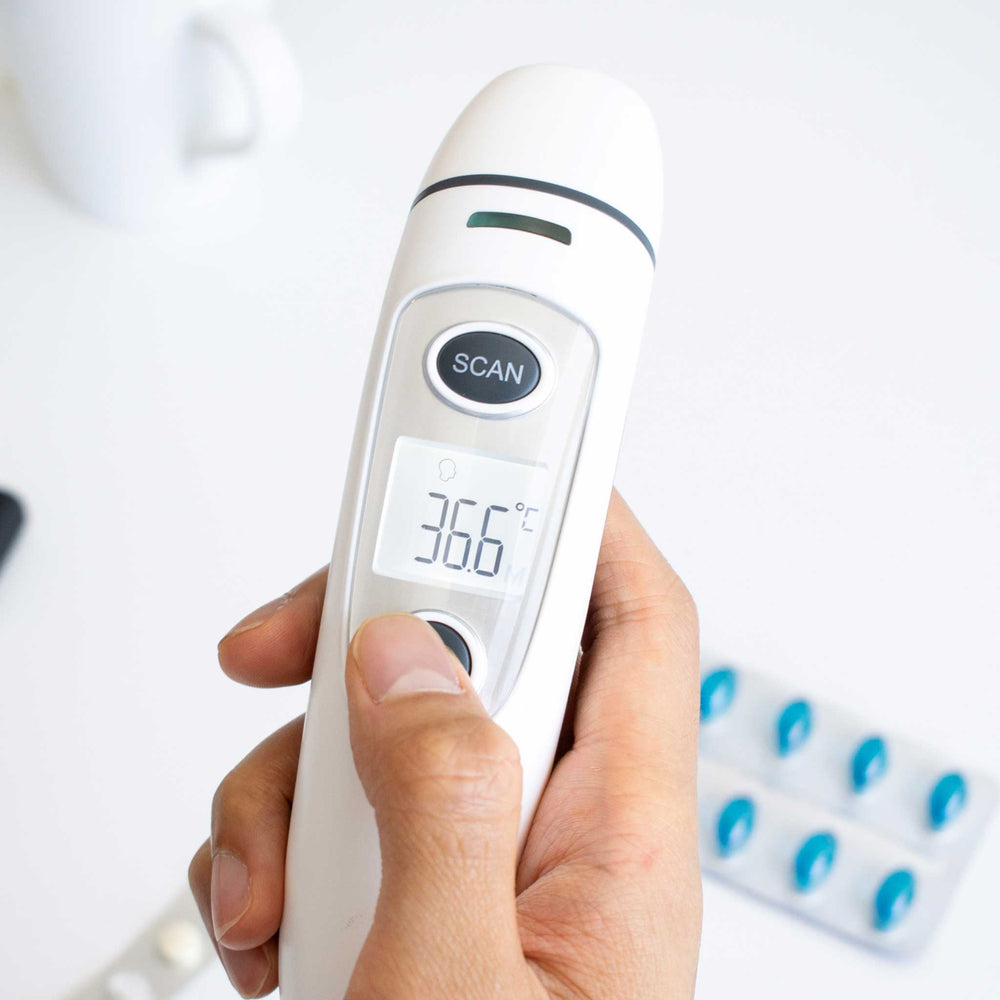 Digital thermometer being held with a blurred background