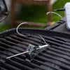 Thermometer probe on a grill with a blurred outdoor background