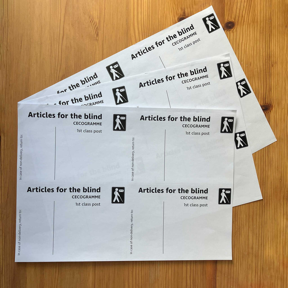 Three A4 sheets of Articles for the blind labels fanned on a wooden surface
