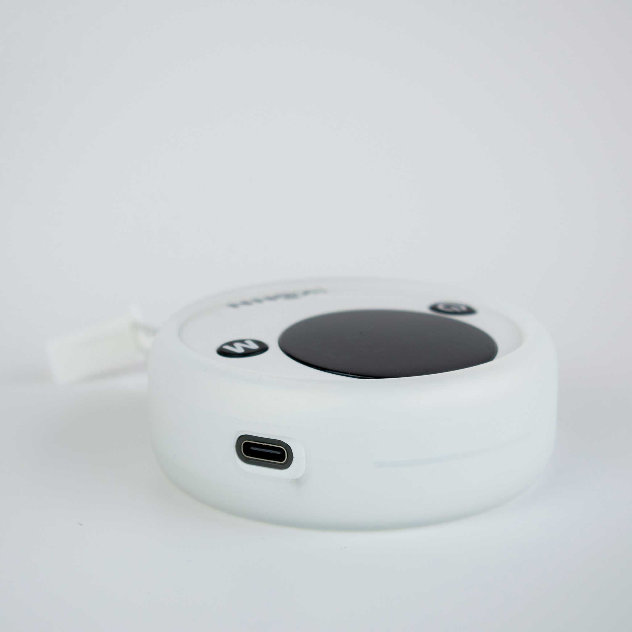 Ikonn tape measure on a white surface with the charging lead attached.