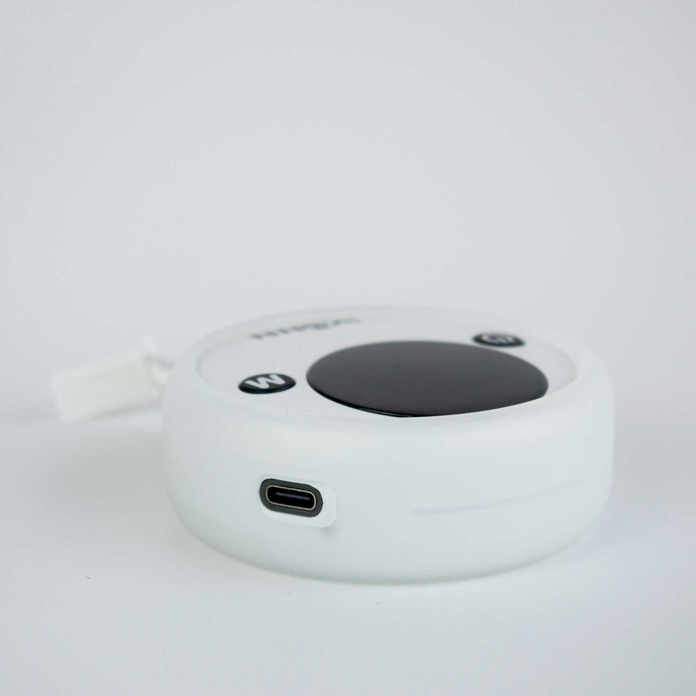 Ikonn tape measure on a white surface with the charging lead attached.